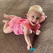 Lettie joined the competition — help win amazing prizes! baby, child, pink_dress, smiling, pacifier, carpet, indoor, cute, happy, toddler, toy, stuffed_animal, playful, infant, casual, portrait, young_child, crawling, bright, person