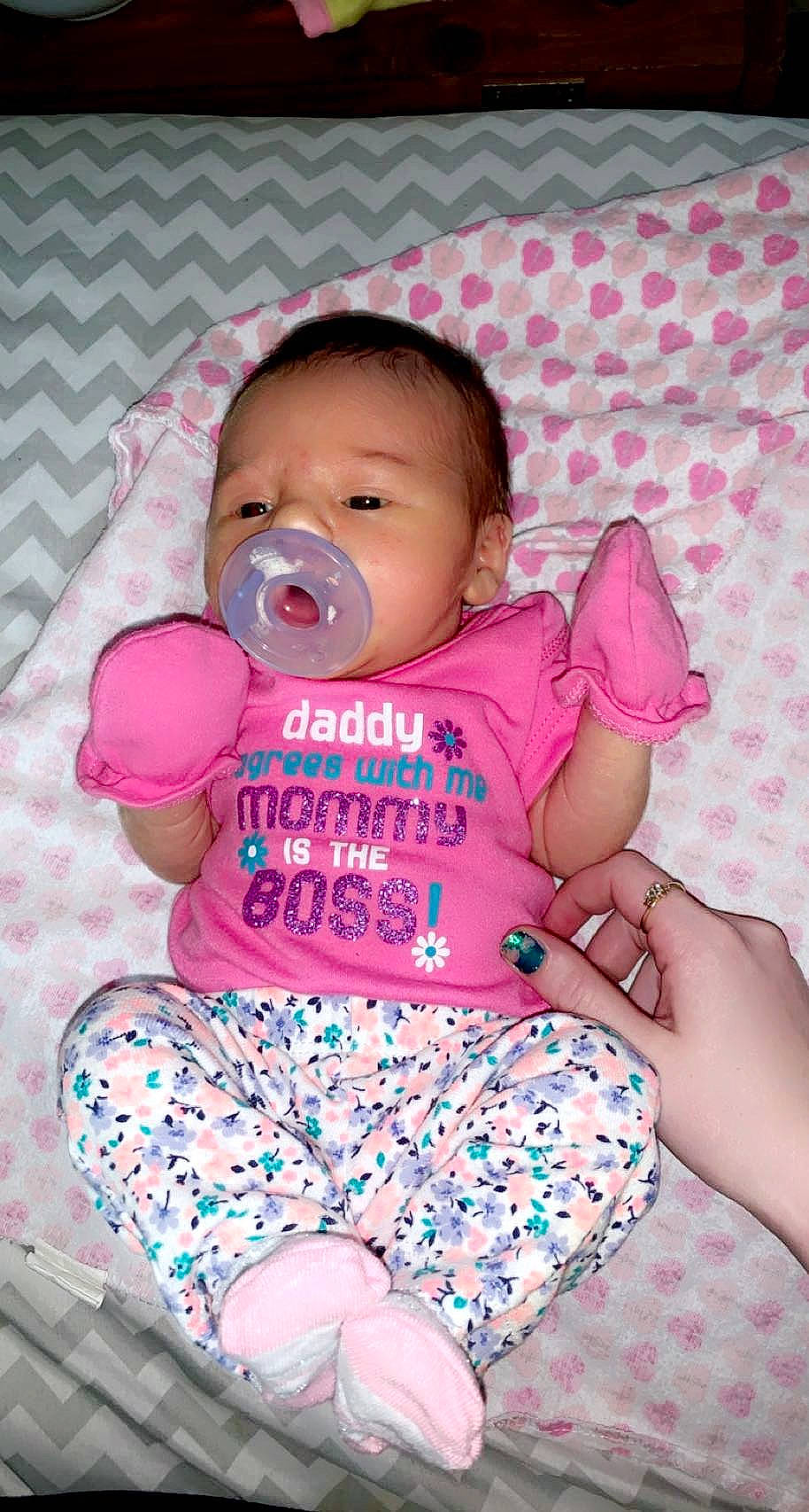 Chanell is registered to the contest to win money with this photo: baby, baby_toddler_clothing, chair, cheek, comfort, eye, face, facial_expression, finger, fun, happy, head, magenta, mouth, person, pink, sitting, skin, sleeve, textile