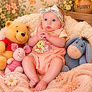 Alex is registered to the contest to win money with this photo: baby, infant, plush_toy, winnie_the_pooh, piglet, eeyore, blanket, headband, flower, honey_pot, cute, smiling_toy, soft_texture, child, indoor, portrait, seated, cozy, decor, colorful