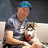 Haru a rejoint le concours — aidez-le/la à gagner de superbes lots ! bandana, blue_cap, casual_clothing, companion, couch, dog, friendly, husky, indoor, jars, leisure, man, pet, puppy, seated, shelf, shorts, smile, sunglasses, tongue_out