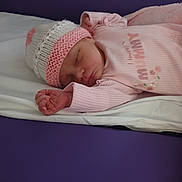 Erica joined the competition — help win amazing prizes! baby, newborn, sleeping, hat, pink_clothing, blanket, soft, infant, cozy, resting, peaceful, cute, portrait, child, indoors, sleepwear, knitted_hat, human, lying_down, toddler