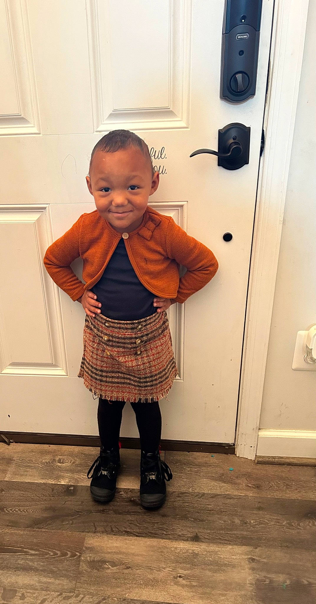 Amya is registered to the contest to win money with this photo: baby, baby_toddler_clothing, child, door, dress, fashion_design, flooring, joint, joy, outerwear, pattern, person, plaid, shoe, shoulder, sleeve, smile, tartan, tie, toddler