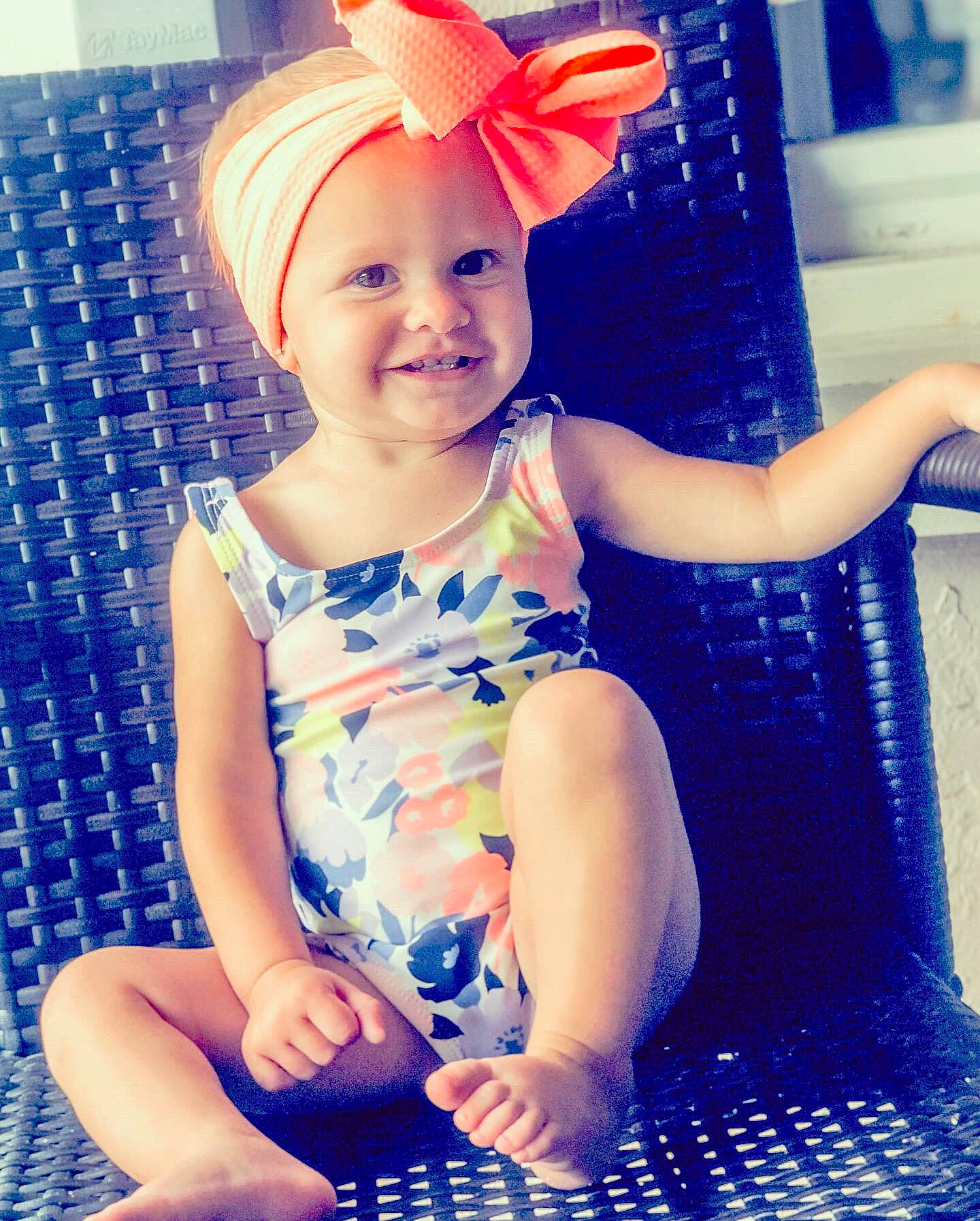 Kennadi is registered to the contest to win money with this photo: blue, child, child_model, clothing, ear, eye, fawn, fun, happy, headgear, joy, person, plant, play, sitting, smile, toddler