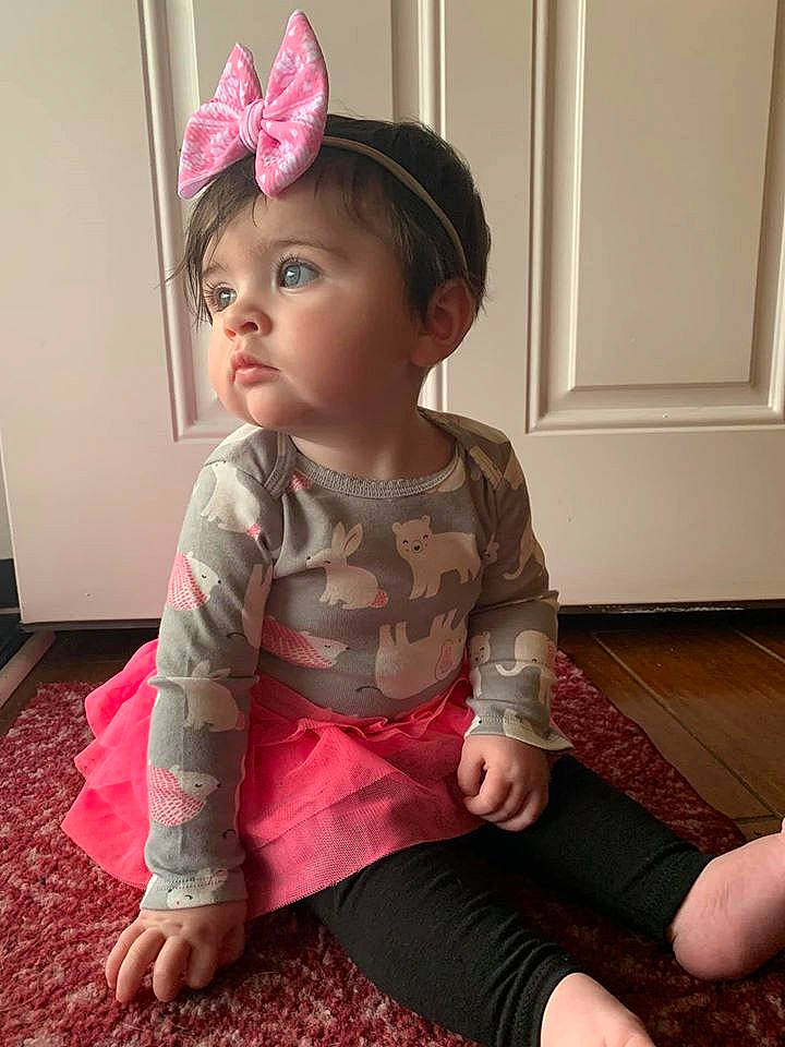 Keagan is registered to the contest to win money with this photo: baby_toddler_clothing, cheek, child, ear, fashion_accessory, fawn, hair_accessory, head, headband, headgear, leg, person, pink, play, sitting, skin, sleeve, toddler