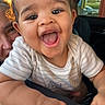 baby, child, smiling, happy, portrait, face, car, vehicle, car_window, seated, infant, outdoor, sunlight, warm_lighting, road_trip, adult, parent, striped_shirt, joy, photography