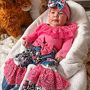 Harlow is registered to the contest to win money with this photo: baby, infant, child, headband, bow, pink_clothing, lace, stuffed_animal, plush_toy, blanket, nursery, lounger, portrait, smile, hands, feet, soft_fabric, crib, cute, decor