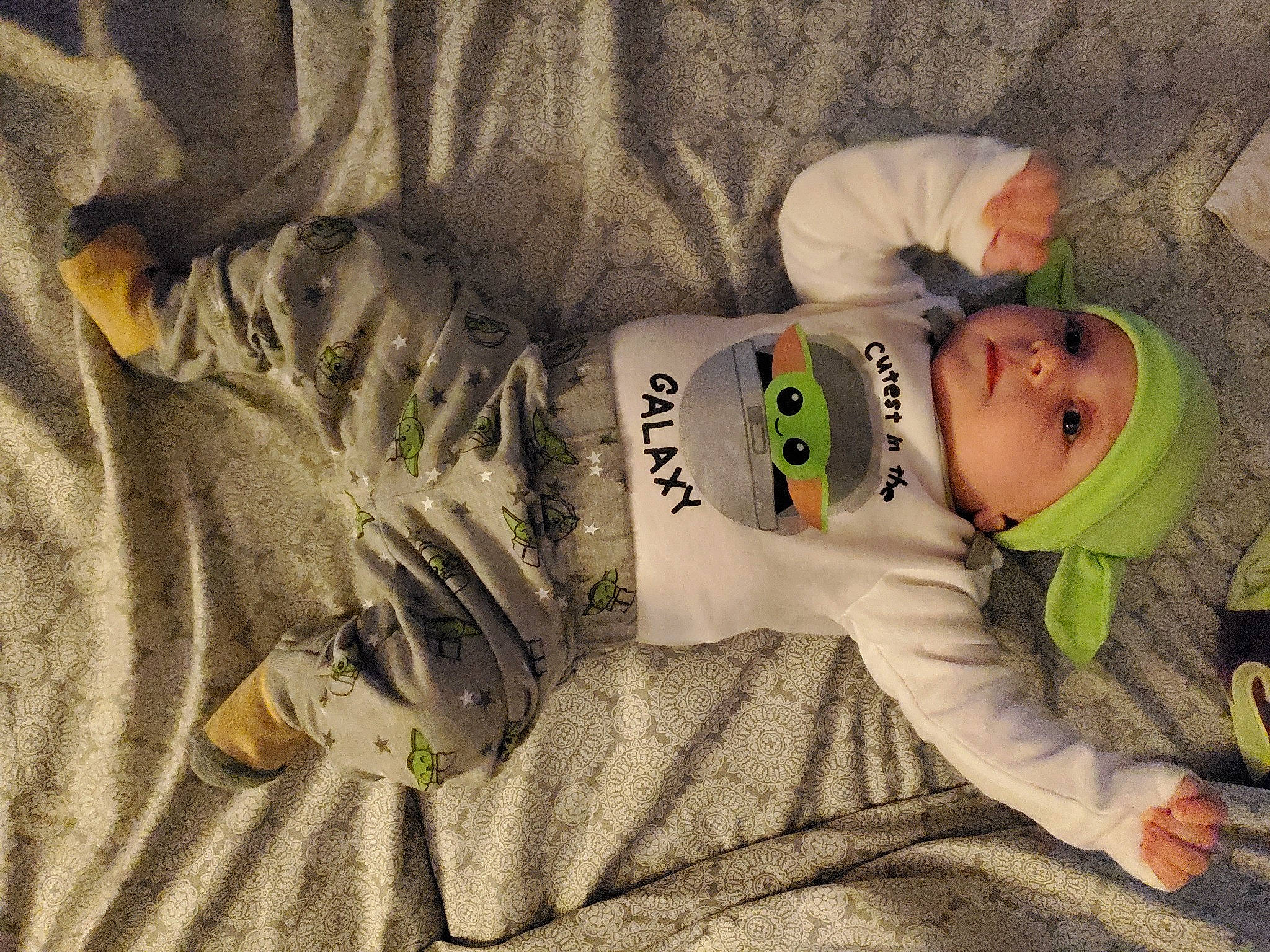 Callum is registered to the contest to win money with this photo: baby, baby_toddler_clothing, carmine, child, comfort, flooring, fur, grass, happy, hat, headwear, linens, pattern, person, personal_protective_equipment, room, sitting, sleeve, smile, textile