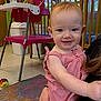 toddler, child, smiling, red_hair, striped_clothing, indoor, high_chair, ball, carpet, daycare, playroom, person, baby, holding, furniture, window, toy, colorful, happy, face