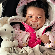 Luna participe au concours pour gagner de l'argent avec cette photo : baby, pacifier, plush_toy, bunny, blanket, pink_jacket, curly_hair, infant, cute, child, soft_toy, wrapped, warm_clothing, indoor, portrait, newborn, cozy, car_seat, baby_clothes, snug