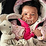 baby, pacifier, plush_toy, bunny, blanket, pink_jacket, curly_hair, infant, cute, child, soft_toy, wrapped, warm_clothing, indoor, portrait, newborn, cozy, car_seat, baby_clothes, snug