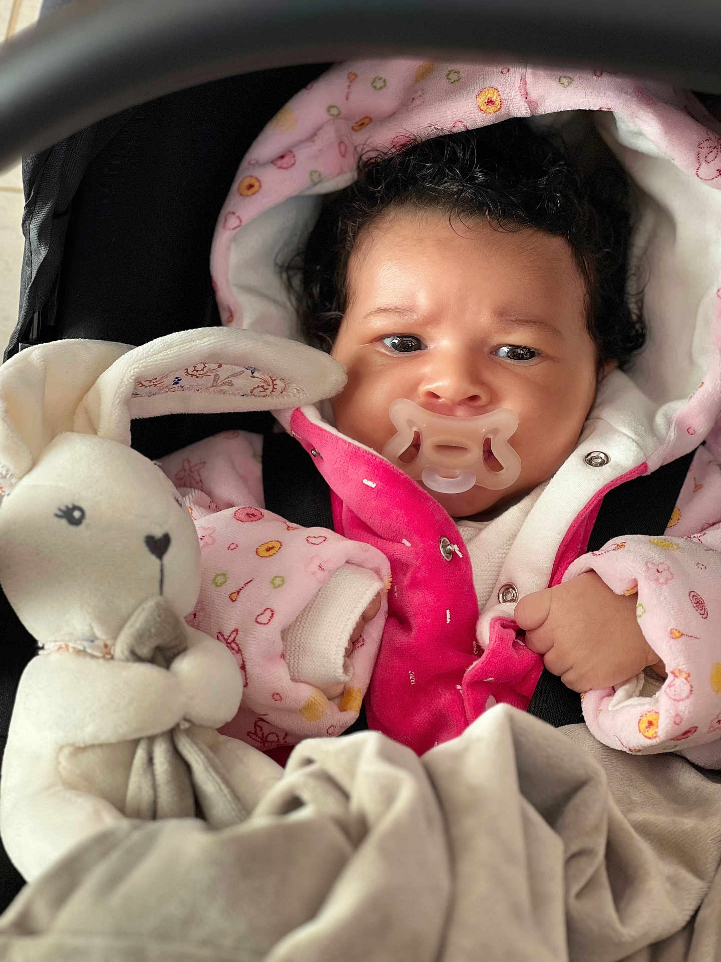 Luna participe au concours pour gagner de l'argent avec cette photo : baby, pacifier, plush_toy, bunny, blanket, pink_jacket, curly_hair, infant, cute, child, soft_toy, wrapped, warm_clothing, indoor, portrait, newborn, cozy, car_seat, baby_clothes, snug