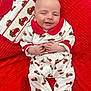baby, infant, smiling, pajamas, red, white, blanket, christmas, holiday, pattern, clothing, cute, child, face, hands, lying_down, cozy, happy, indoors, portrait