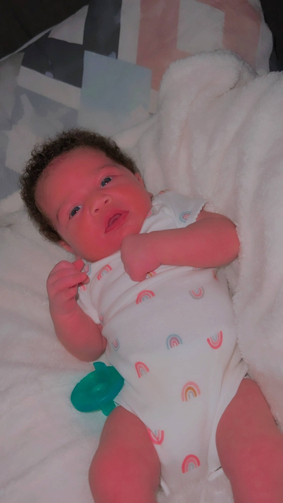 Emani is registered to the contest to win money with this photo: baby, baby_toddler_clothing, carmine, cheek, child, comfort, face, facial_expression, head, iris, linens, pattern, person, pink, room, skin, sleeve, smile, textile, toddler