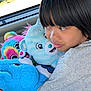 child, plush_toys, bear, car_interior, window, daylight, toy, cuddling, colorful, soft, hair, face, clothing, seat, cute, portrait, person, happy, childhood, indoors
