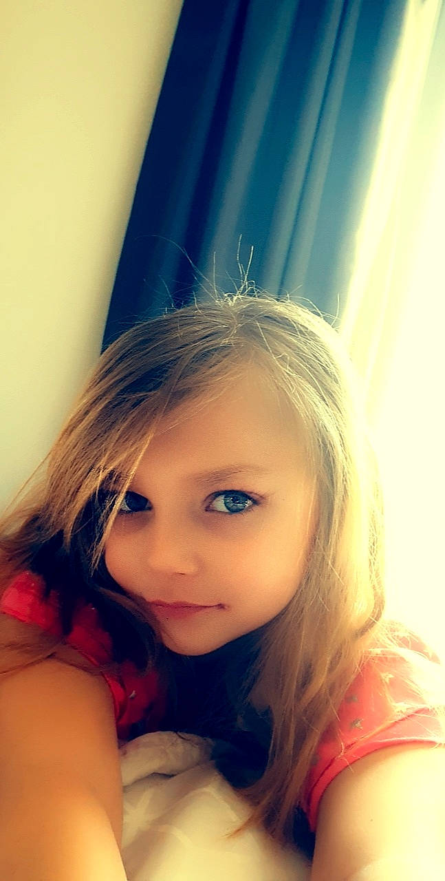 Niya is registered to the contest to win money with this photo: blond, brown_hair, child, cloud, curtain, electric_blue, eyebrow, eyelash, flash_photography, fun, happy, iris, layered_hair, lip, long_hair, nose, person, selfie, surfer_hair, tints_and_shades