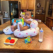 De'Ari is registered to the contest to win money with this photo: baby, infant, toy, bottle, kitchen, countertop, seat, inflatable, cabinet, wood, refrigerator, food, child, cute, indoor, table, play, colorful, person, home