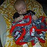 Nehemiah is registered to the contest to win money with this photo: baby, sleeping, blanket, cushion, yellow, red, patterned, cozy, infant, clothing, white_socks, resting, indoor, soft, peaceful, child, face, hands, portrait, cute