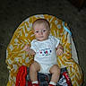 baby, infant, onesie, socks, blanket, patterned_blanket, carpet, indoor, baby_seat, red, white, yellow, cute, child, portrait, clothing, footwear, celebration, holiday, expression