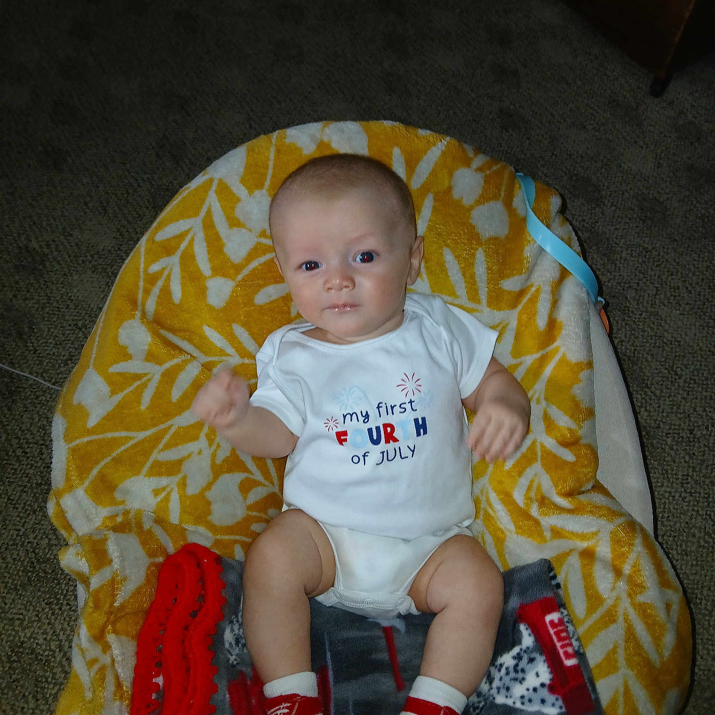 Nehemiah joined the competition — help win amazing prizes! baby, infant, onesie, socks, blanket, patterned_blanket, carpet, indoor, baby_seat, red, white, yellow, cute, child, portrait, clothing, footwear, celebration, holiday, expression