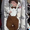 baby, infant, pacifier, bow_tie, cap, suspenders, brown_pants, baby_lounger, leaf_pattern, clothing, cute, lying_down, indoors, child, newborn, fashion, comfortable, small_hands, face, portrait