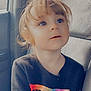 child, toddler, car_seat, seat, clothing, shirt, text_on_clothing, rainbow_colors, long_sleeves, hair, face, eyes, expression, indoors, car_interior, window, seatbelt_slot, portrait, cute, curly_hair