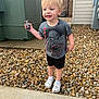 Waylon is registered to the contest to win money with this photo: child, toddler, toy_car, spiderman_tshirt, shorts, white_socks, crocs, rocks, sidewalk, outdoor, smiling, blond_hair, playful, concrete, building, utility_box, gravel, daylight, person, casual_clothing