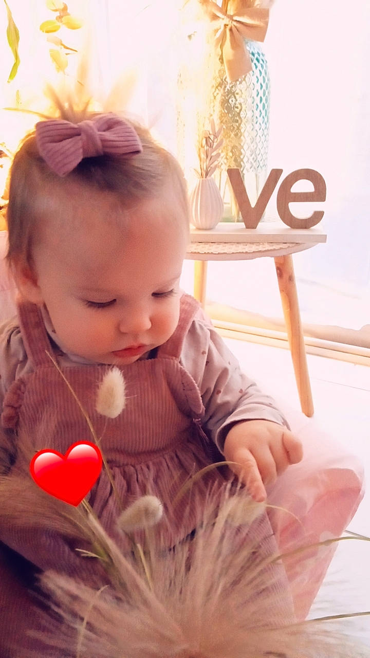 Lanna participe au concours pour gagner de l'argent avec cette photo : baby, baby_toddler_clothing, chair, child, dress, facial_expression, fashion_accessory, flooring, grass, hairstyle, happy, iris, peach, person, petal, pink, room, sitting, skin, toddler