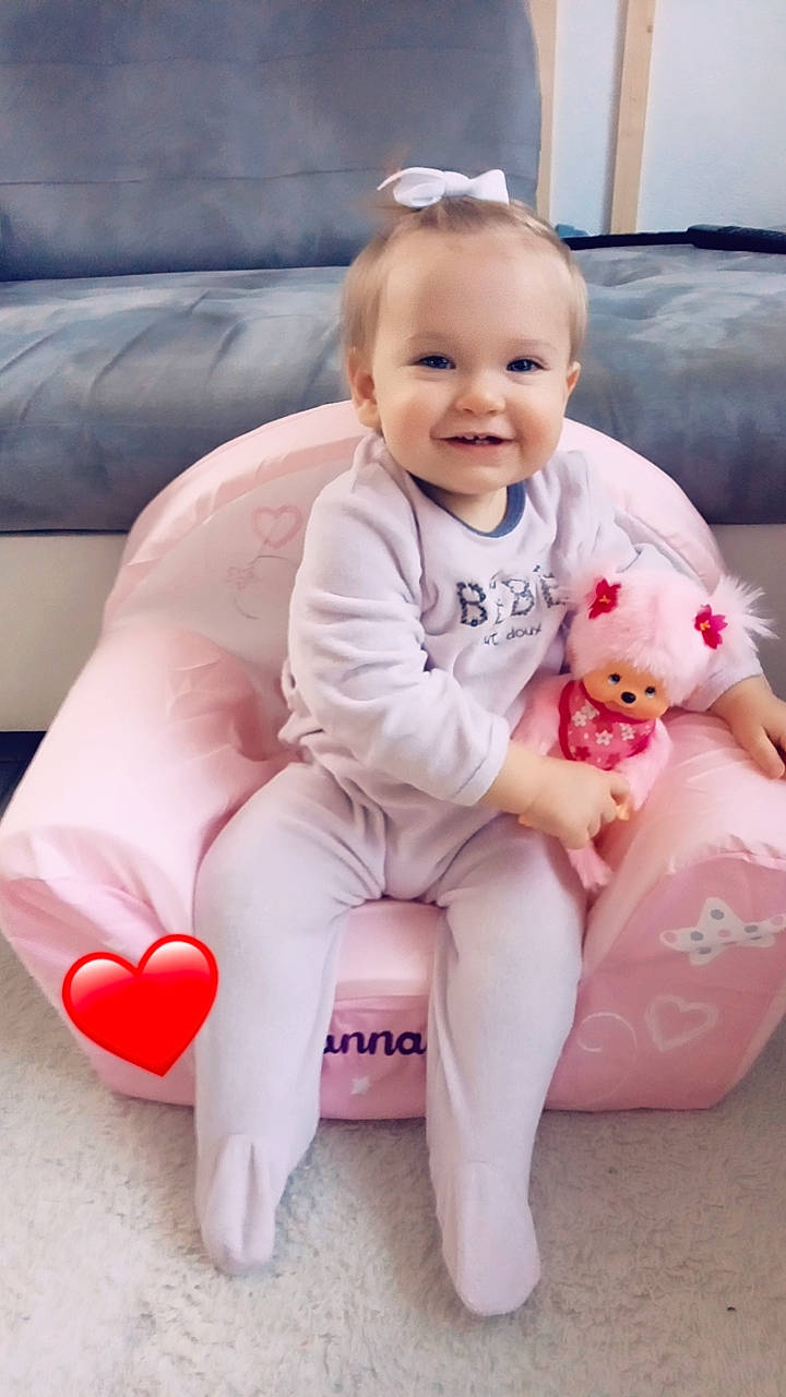 Lanna participe au concours pour gagner de l'argent avec cette photo : arm, baby, baby_toddler_clothing, comfort, couch, face, happy, head, human_body, human_leg, joy, knee, leg, person, pink, product, sitting, skin, smile, thigh