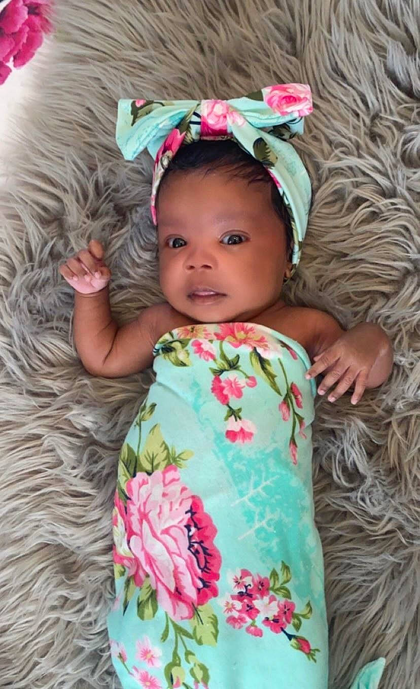 Kori is registered to the contest to win money with this photo: baby, baby_toddler_clothing, cheek, chin, dress, facial_expression, fashion, green, hairstyle, happy, head, human, iris, organ, person, pink, plant, skin, sleeve, textile