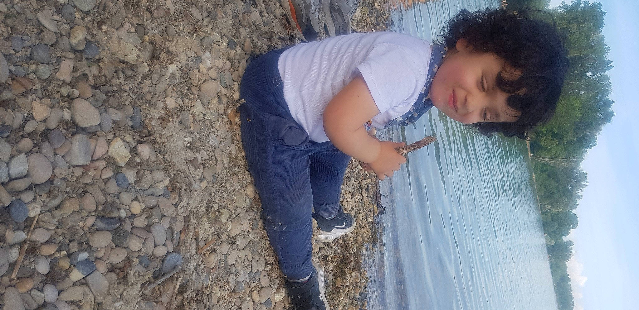 Aylan participe au concours pour gagner de l'argent avec cette photo : baby, child, electric_blue, fun, grass, happy, human_leg, leg, leisure, people_in_nature, person, plant, rock, shadow, sitting, soil, toddler, tree, vacation, winter