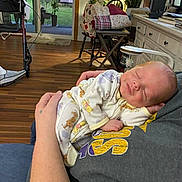 Samuel joined the competition — help win amazing prizes! baby, sleeping, newborn, pajamas, arms, person, indoor, wooden_floor, chair, table, lamp, plant, window, blanket, home, comfort, peaceful, face, infant, resting