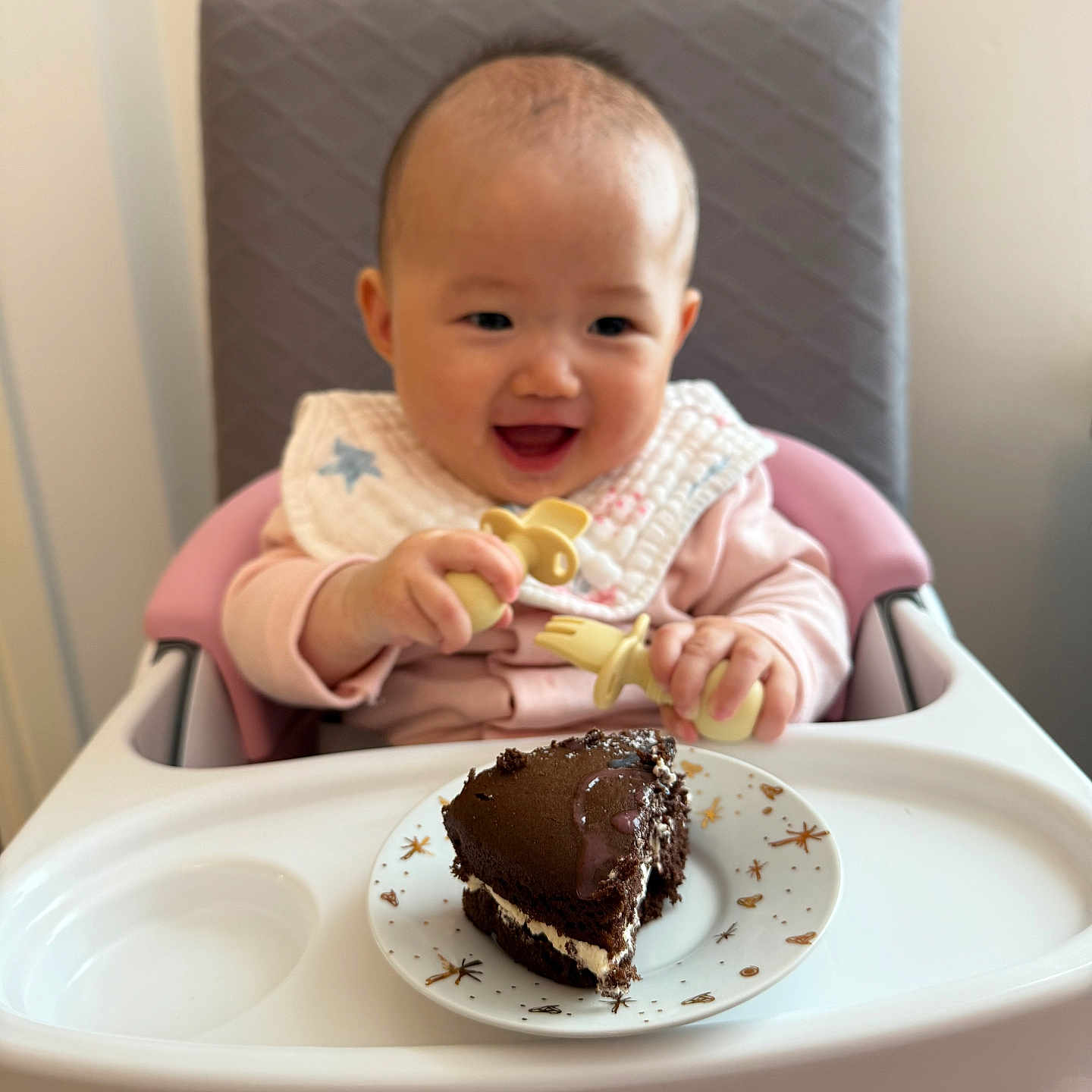 Amelia joined the competition — help win amazing prizes! baby, cake, celebration, child, chocolate_cake, cute, dessert, feeding, food, happy, high_chair, indoor, infant, pacifier, person, pink, plate, smiling, table, white