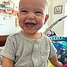 baby, child, smiling, laughing, onesie, indoor, playmat, toy, happy, cute, infant, portrait, face, person, bright, colorful, short_sleeve, buttoned, home, young