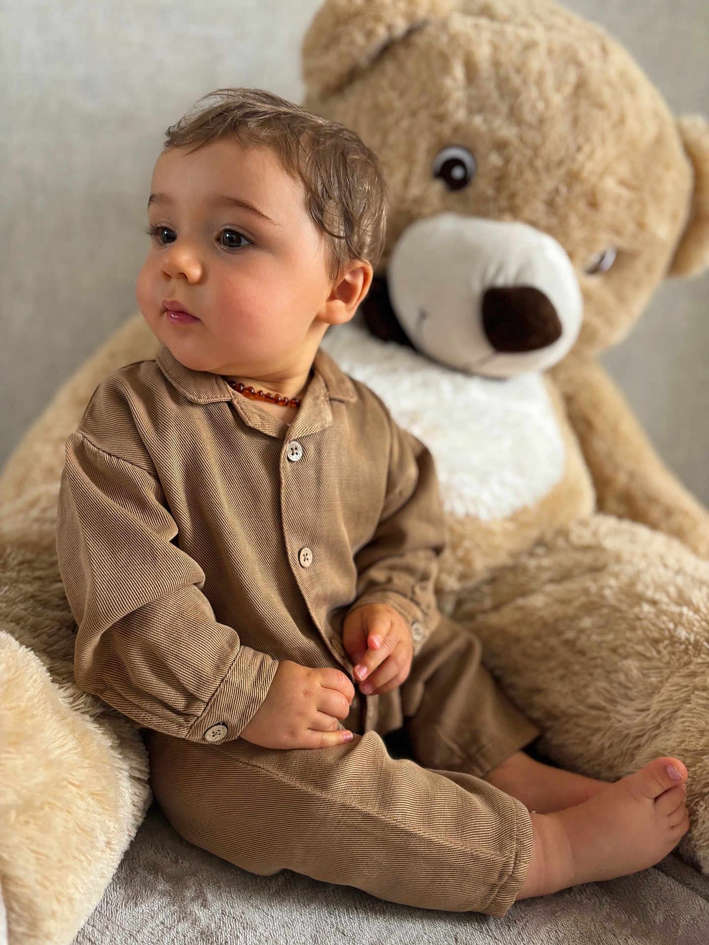 Awen a rejoint le concours — aidez-le/la à gagner de superbes lots ! toddler, child, pajamas, brown_clothing, teddy_bear, plush_toy, soft_texture, indoor, sitting, cute, portrait, baby, childhood, comfort, toy, face, hands, feet, warm_colors, cozy