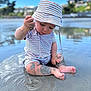 Awen participe au concours pour gagner de l'argent avec cette photo : baby, child, striped_clothing, hat, sand, water, beach, sitting, wet, legs, feet, hand, play, outdoor, nature, curious, summer, sunny, ripples, closeup