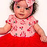baby, child, infant, curly_hair, headband, pink_clothing, red_skirt, tutu, smiling, cute, portrait, studio_photo, white_background, fashion, adorable, young_child, person, happy, closeup, face