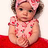 Lillyonna joined the competition — help win amazing prizes! baby, child, infant, headband, bow, curly_hair, pink_clothing, red_skirt, tutu, sitting, hands_clasped, cute, portrait, studio, white_background, cherry_pattern, expression, looking_at_camera, adorable, young