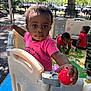 Kaylani joined the competition — help win amazing prizes! toddler, child, playpen, red_ball, pink_shirt, outdoor, playground, fence, trees, shade, toy, play_mat, parked_cars, curious, daylight, kids_playing, plastic_fence, baby, park, summer