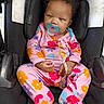Katyria joined the competition — help win amazing prizes! baby, child, pacifier, car_seat, pajamas, colorful, floral_pattern, cute, infant, seated, curly_hair, blue_pacifier, clip, indoors, portrait, looking_at_camera, clothing, comfort, black_car_seat, young_child