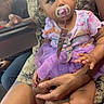adult, baby, calm, casual, child, clothing, colorful, curious, curly_hair, cute, hand, indoor, lap, pacifier, people, person, pink_shoes, purple_tutu, sitting, skin