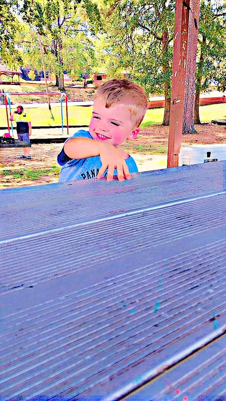Carson is registered to the contest to win money with this photo: asphalt, child, city, electric_blue, fun, grass, happy, joy, leisure, magenta, outdoor_play_equipment, outdoor_recreation, people_in_nature, person, plant, playground, purple, recreation, sidewalk, toddler