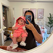 Alina joined the competition — help win amazing prizes! baby, adult, mirror, selfie, nursery, baby_clothing, coral_outfit, hood, white_shoes, wall_art, plant, mobile, crib, furniture, room_decor, person, holding, reflection, indoor, photography