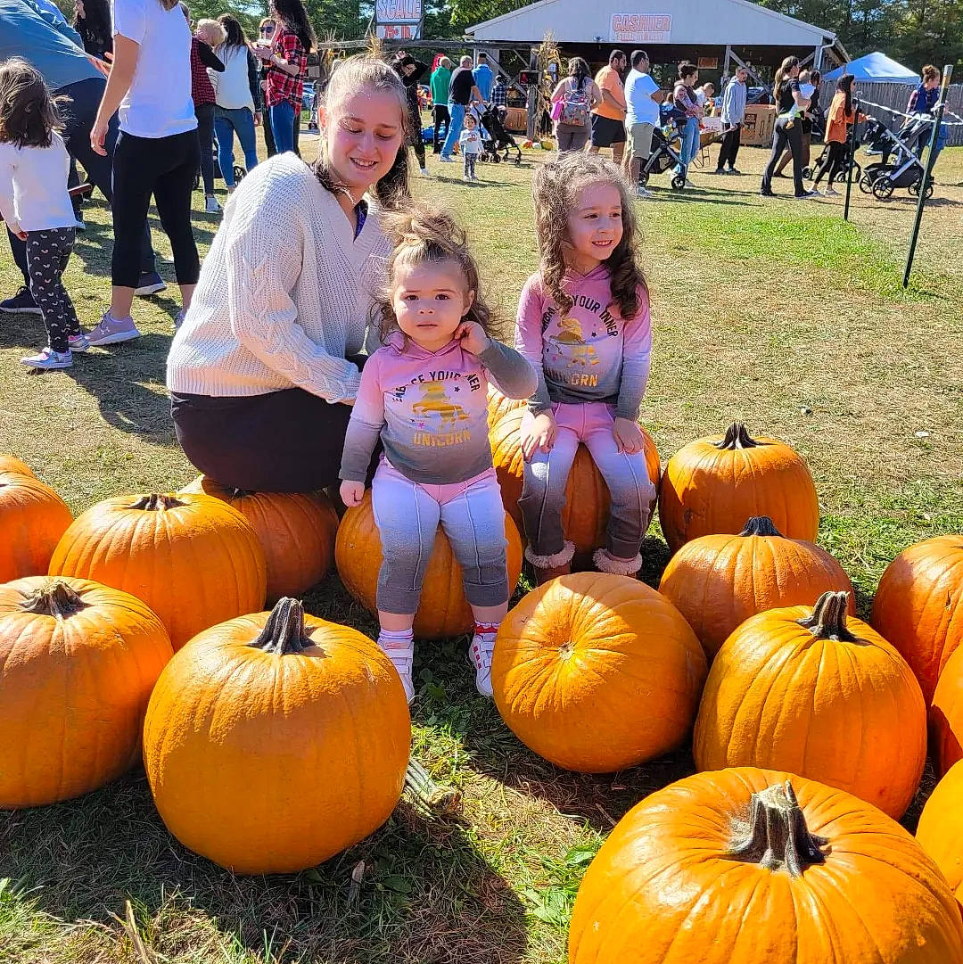 Gianna joined the competition — help win amazing prizes! calabaza, cucurbita, event, food, gourd, grass, joy, leaf, local_food, natural_foods, person, plant, produce, pumpkin, shorts, smile, squash, sunglasses, tent, vegetable