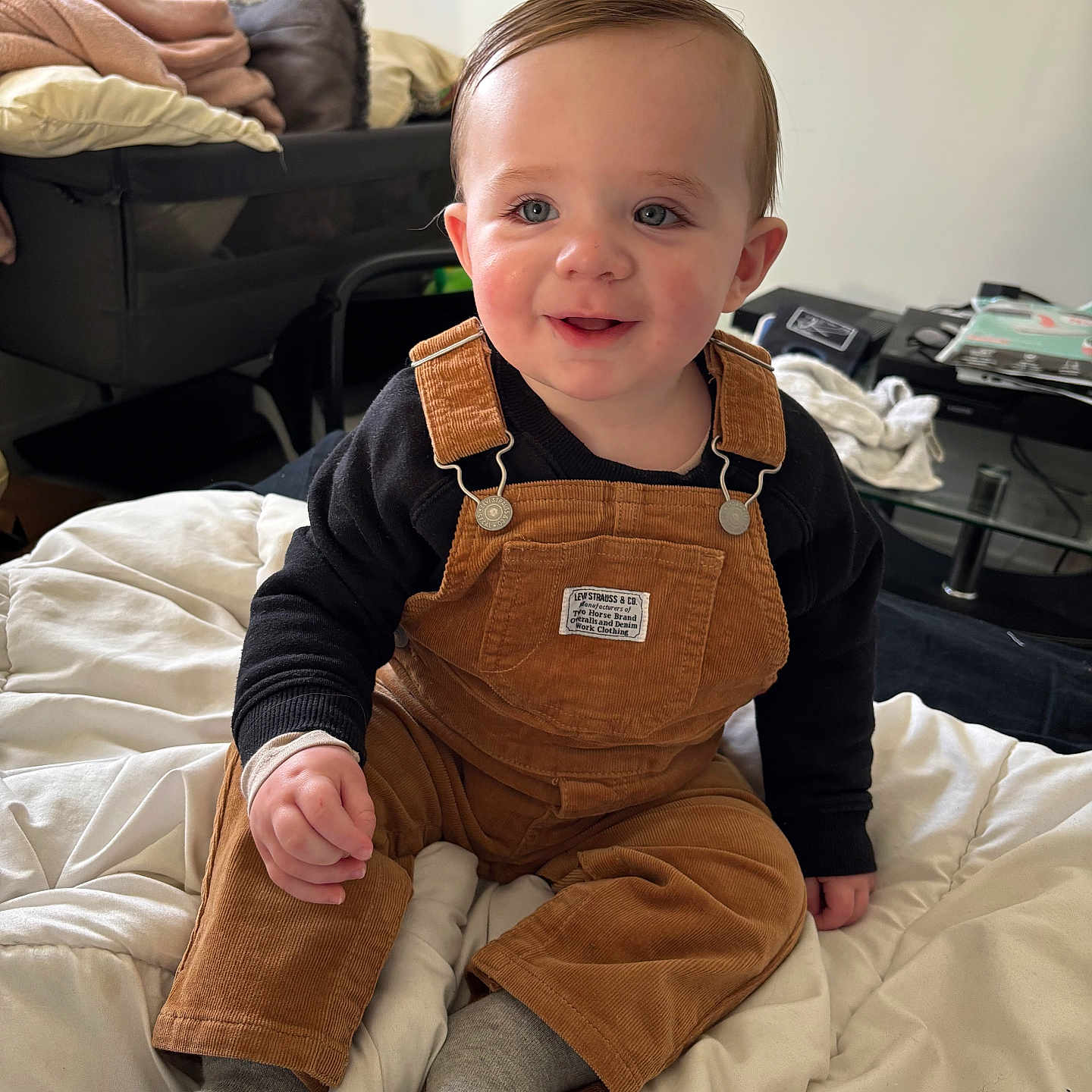 Naëlyo a rejoint le concours — aidez-le/la à gagner de superbes lots ! baby, bassinet, bed, black_sweater, blanket, blue_eyes, child, corduroy_overalls, feet, glass_table, gray_socks, hand, indoor, magazines, pillow, playpen, portrait, rosy_cheeks, smiling, toddler