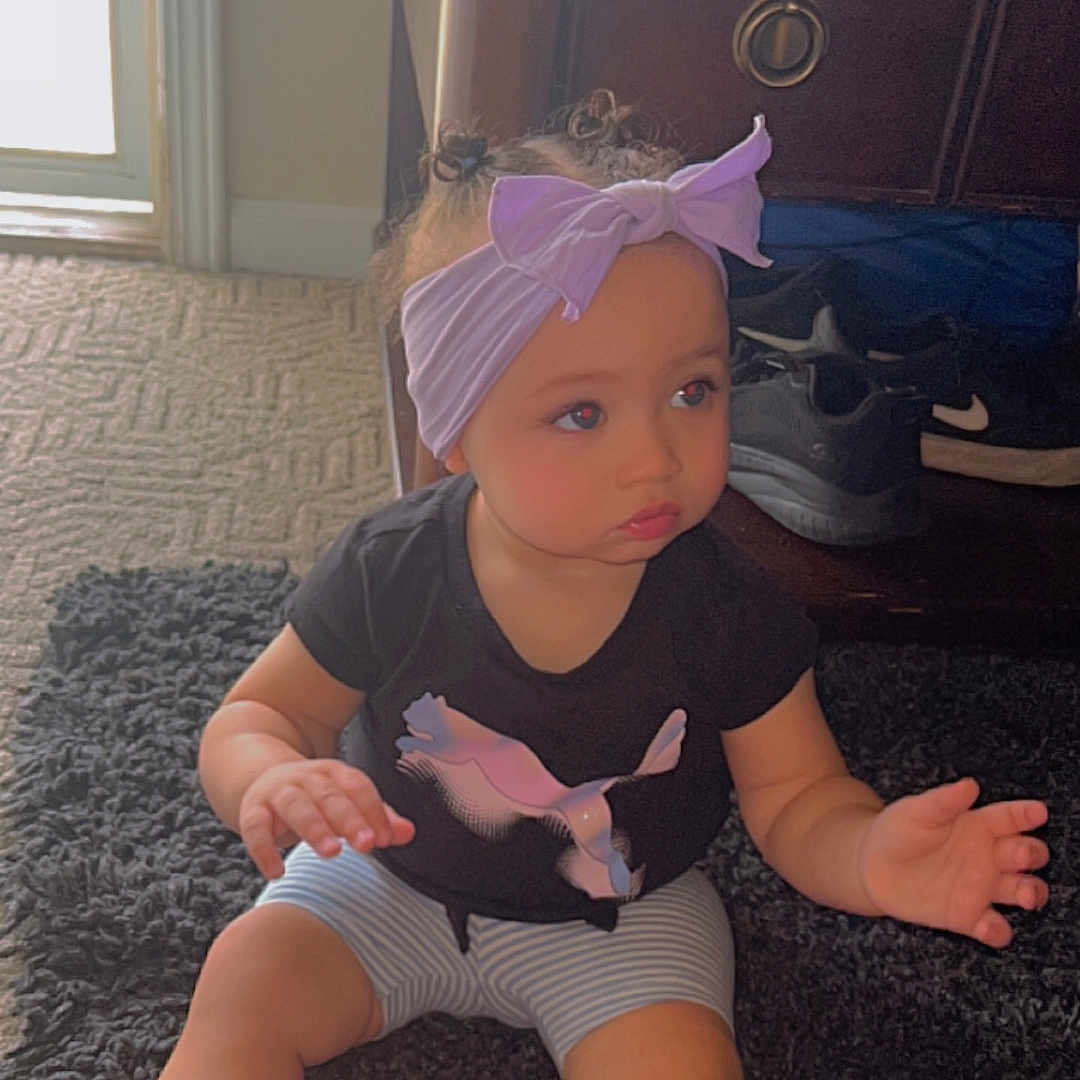 Kensleigh is registered to the contest to win money with this photo: accessories, bodypart, child, clothing, face, female, finger, footwear, girl, hand, hardwood, hat, head, person, photography, portrait, shoe, shorts, sitting, wood