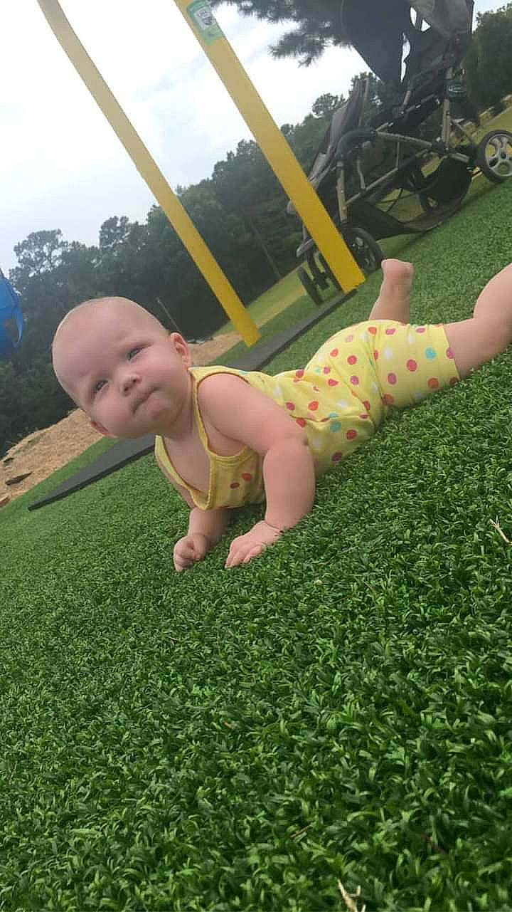 Hailey is registered to the contest to win money with this photo: baby, baby_toddler_clothing, cloud, facial_expression, finger, grass, grass_family, grassland, green, happy, human_body, lawn, leg, leisure, people_in_nature, person, plant, recreation, sky, toddler