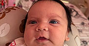 Liam joined the competition — help win amazing prizes! baby, infant, face, portrait, clothing, white_outfit, cushion, bedroom, drawer, colorful_towel, curious, indoors, child, resting, young, person, closeup, soft_lighting, cute, expression