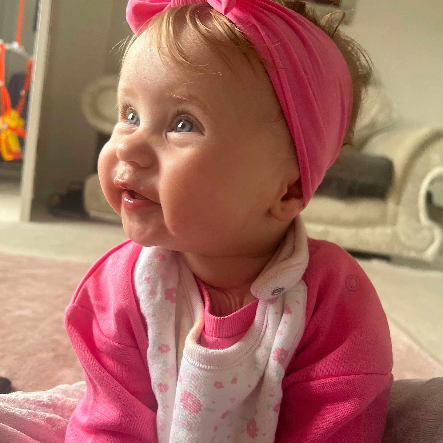 Lilah-Blu is registered to the contest to win money with this photo: accessories, baby, bodypart, clothing, couch, face, finger, furniture, hand, happy, head, headband, hoodie, knitwear, person, photography, portrait, smile, sweater, sweatshirt
