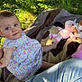 baby, child, floral_dress, outdoor, grass, blanket, plush_toys, sunlight, greenery, person, cute, infant, playing, nature, happy, small_child, sitting, jeans, leg, summer