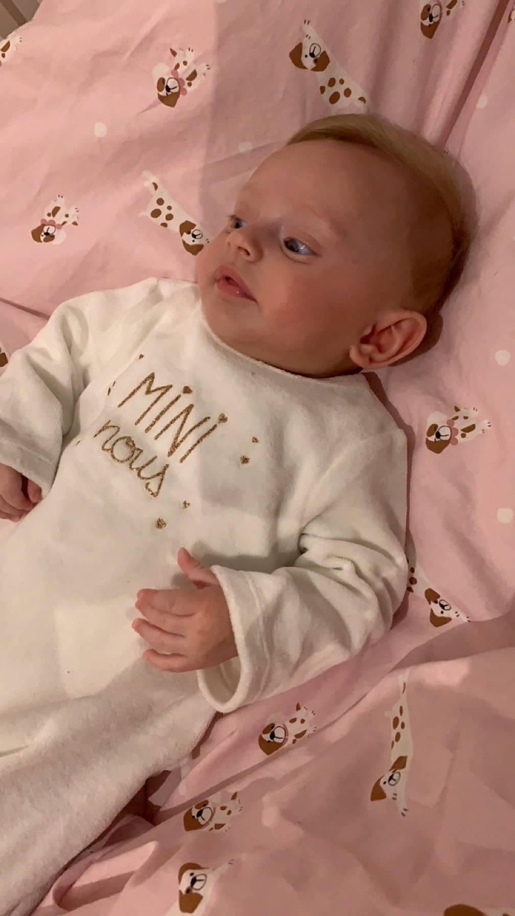 Eden a rejoint le concours — aidez-le/la à gagner de superbes lots ! baby, baby_products, baby_toddler_clothing, cheek, child, comfort, face, happy, linens, pattern, person, pink, room, sitting, skin, sleeve, t_shirt, textile, toddler